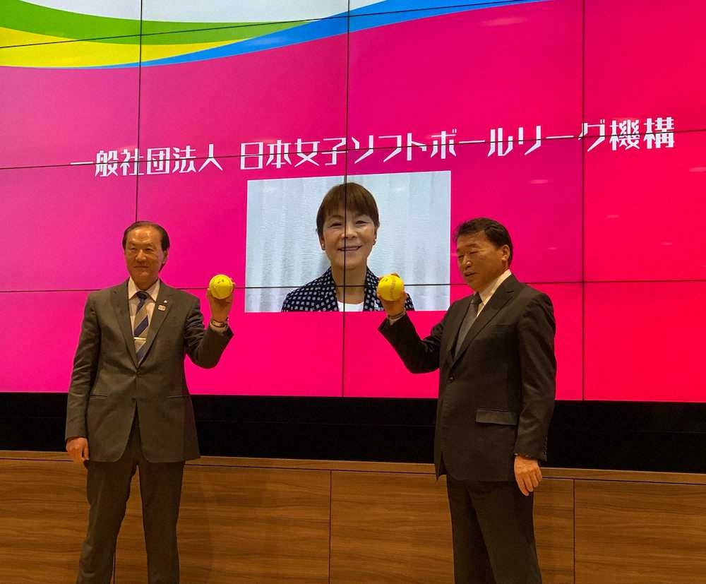 都内で会見した日本女子ソフトボール機構の三宅会長（左）と島田チェアマン。中央は宇津木キャプテンの写真