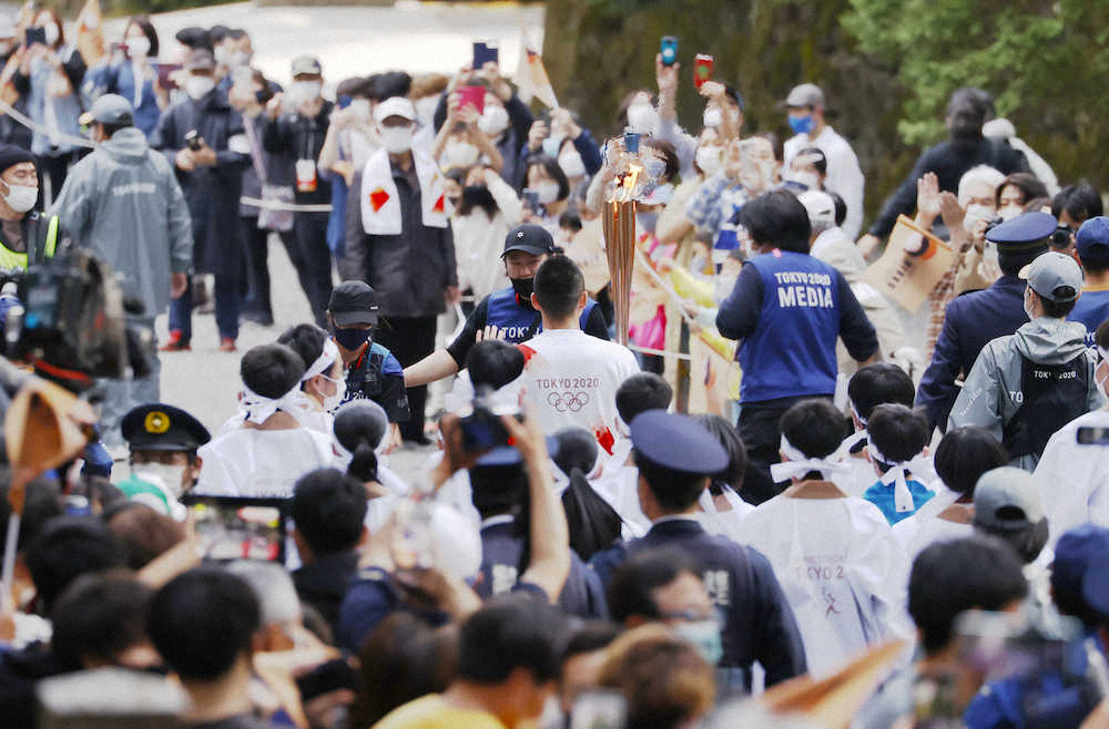 日光東照宮で大勢の人に見守られる聖火ランナー（中央）＝29日午後、栃木県日光市