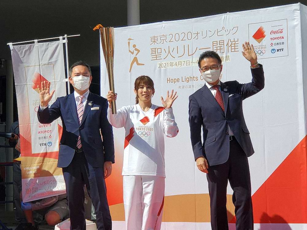 聖火がともったトーチを掲げる吉田沙保里さん（中央）。左は三重県の鈴木知事、右は津市の前葉市長