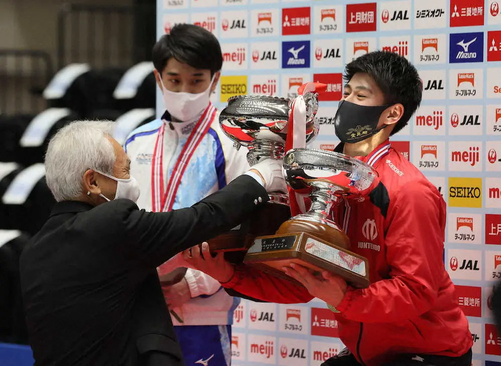 全日本体操個人総合選手権の男子決勝を制し、優勝杯を手にする橋本大輝（右）（代表撮影）