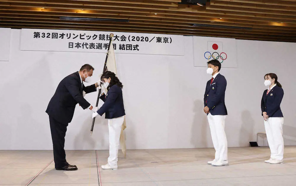 JOC山下会長（左）から団旗を受け取る須崎
