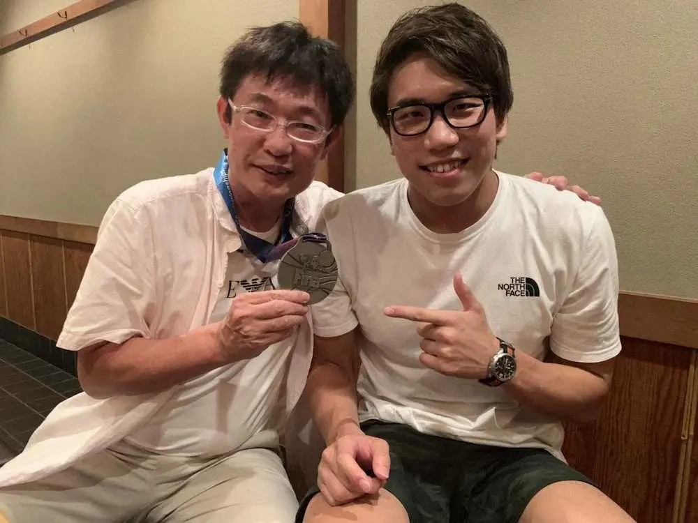 19年世界選手権後に松元（右）の獲得した銀メダルを首からさげる平コーチ