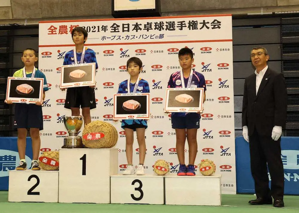 全農杯全日本卓球選手権の表彰式で全農の野口栄代表理事専務(右)から豪華な副賞を贈られるホープス男子の川上流星(左から2人目)ら
