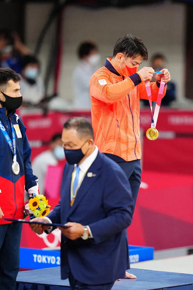 25日の柔道男子66キロ級表彰式でJOC・山下泰裕会長（手前）から金メダルを受け取った阿部一二三