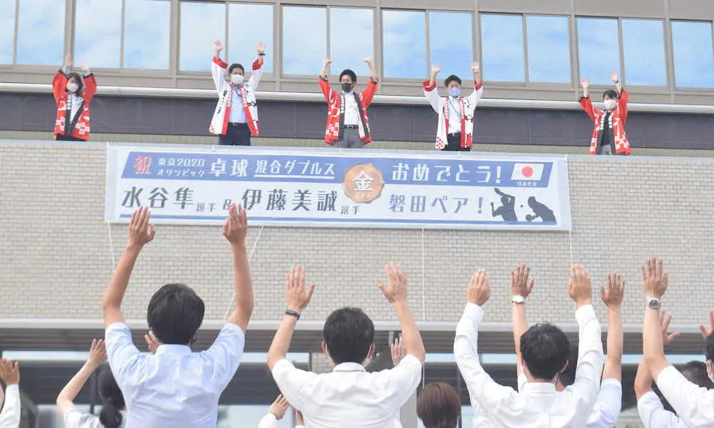 東京五輪卓球複合ダブルスの水谷、伊藤組優勝を祝う横断幕を掲げ、万歳して喜ぶ磐田市職員、市民ら