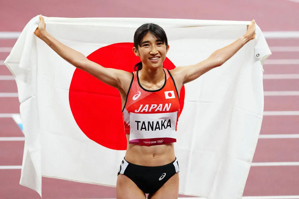 女子1500メートル決勝で8位入賞を果たし日の丸を掲げる田中（撮影・会津　智海）