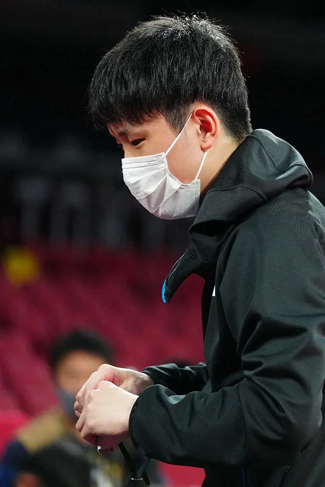 東京五輪卓球男子団体３位決定戦で、水谷隼の眼鏡を手にする張本智和（撮影・会津智海）