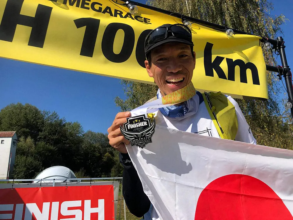 1001キロを完走し、ゴール後にメダルを手に笑顔を見せる北田雄夫氏