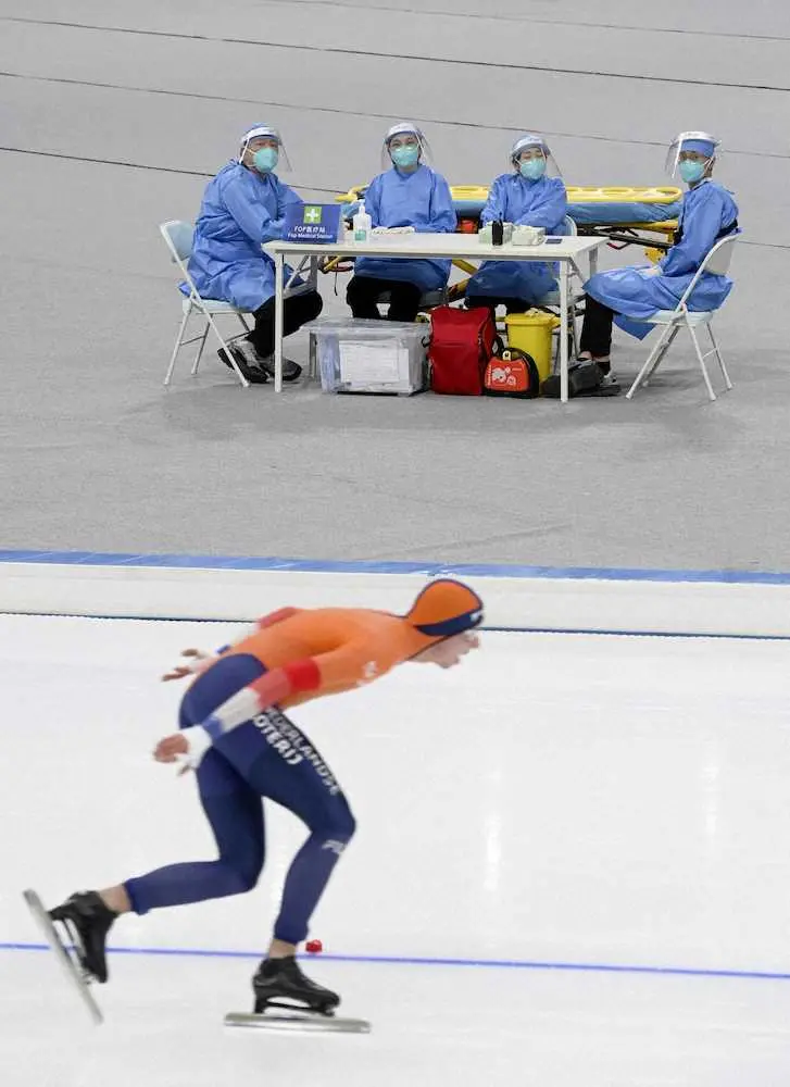 スピードスケートで始まった北京冬季五輪の今季のテスト大会で、防護服姿で待機する医療関係者＝8日、北京の国家スピードスケート館