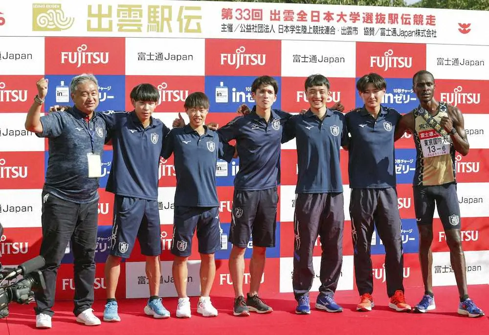 初出場で初優勝を果たし、記念写真に納まる東京国際大の選手らと大志田監督（左端）
