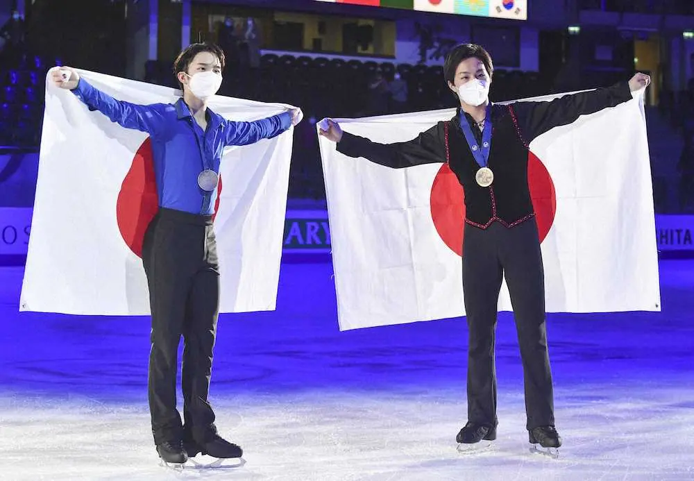 メダルを胸に日の丸を掲げる男子で2位の友野一希（左）と3位の三浦佳生（AP）