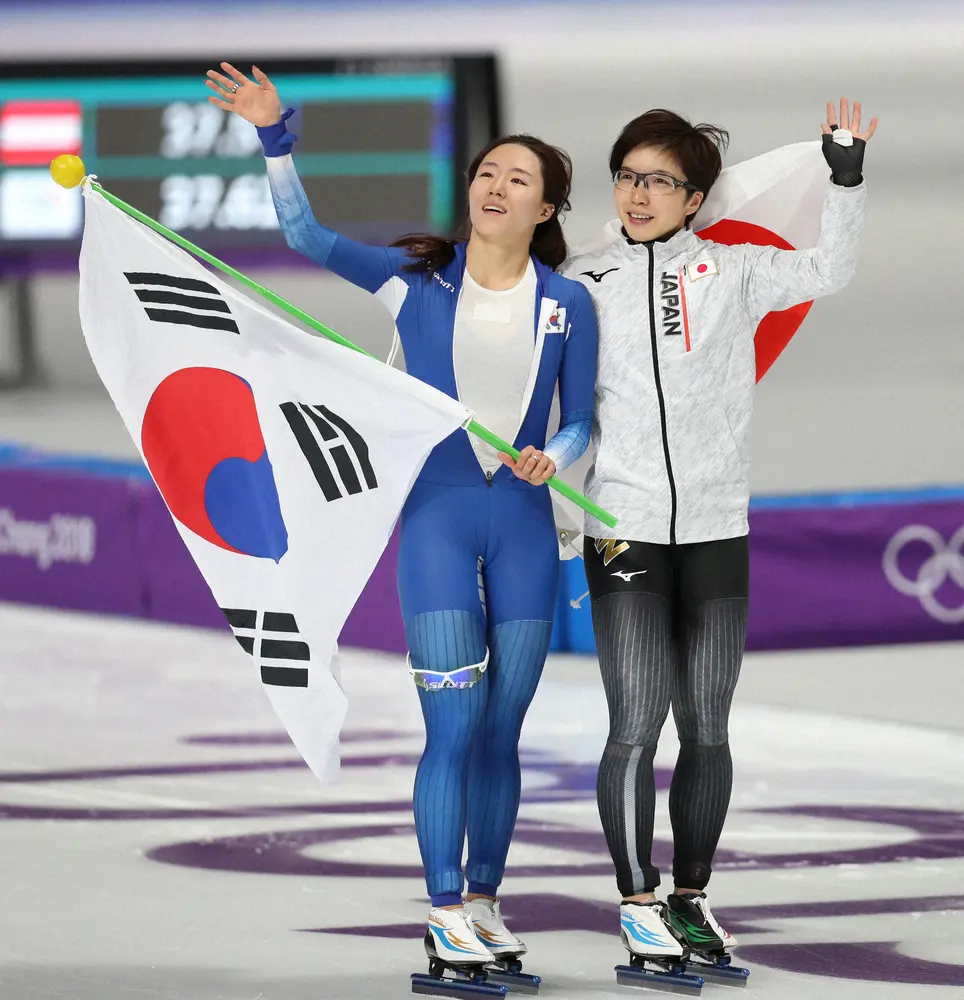 平昌五輪・スピードスケート女子500メートル終了後、銀メダルの李相花（左、韓国）とともに場内を一周する金メダルの小平奈緒　（小海途良幹）