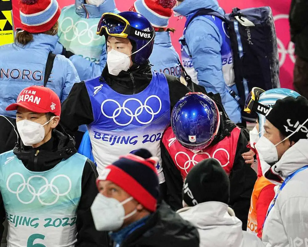 北京五輪ノルディックスキー・ジャンプ混合団体の競技を終え、うなだれる高梨沙羅（中央右）の肩を抱く小林陵侑（同左）