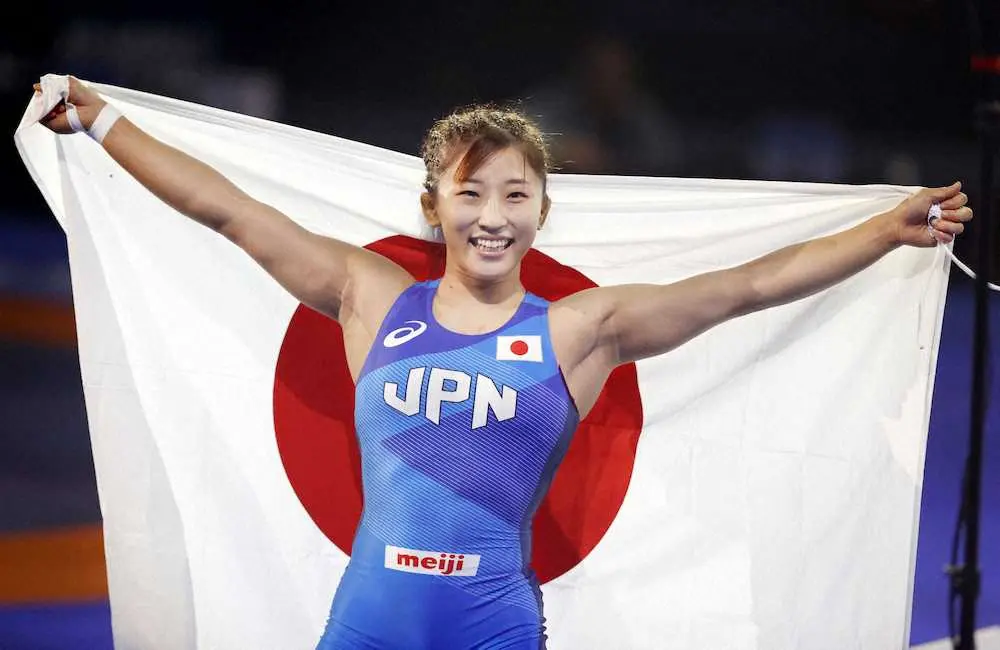 女子50キロ級で優勝し、日の丸を掲げ笑顔の須崎