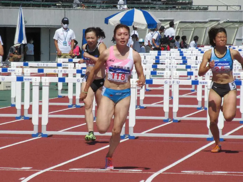 女子100メートル障害予選でゴールする福部（手前）