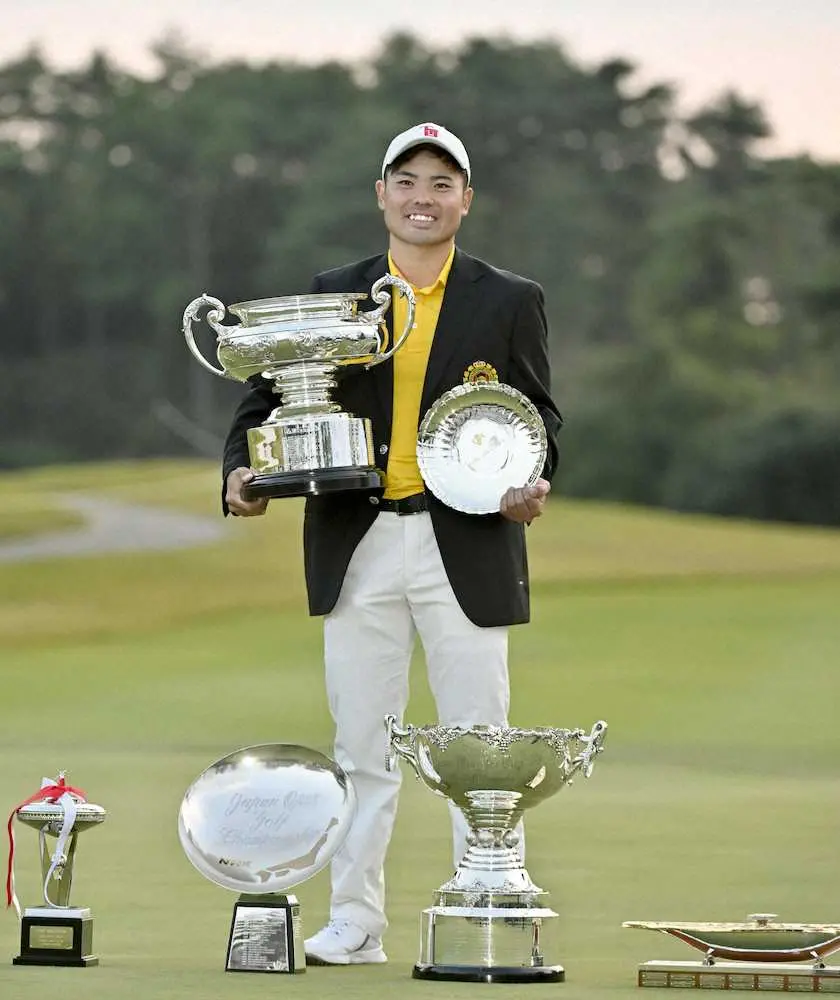 男子ゴルフの日本オープン選手権でアマチュアとして95年ぶりの優勝を果たし、カップを手に笑顔を見せる蝉川泰果