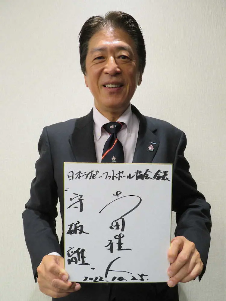 座右の銘「守破離」をしたためた色紙を手に笑顔の日本ラグビー協会の土田雅人会長