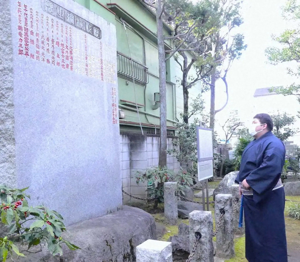 野見宿禰神社の歴代横綱石碑を見つめる落合（撮影・前川　晋作）