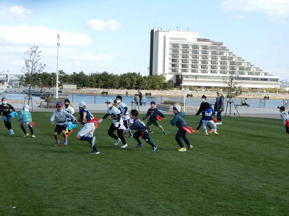 昨年の甲子園ボウルで使用された芝が移設されたメリケンパークの広場で遊ぶ子どもたち
