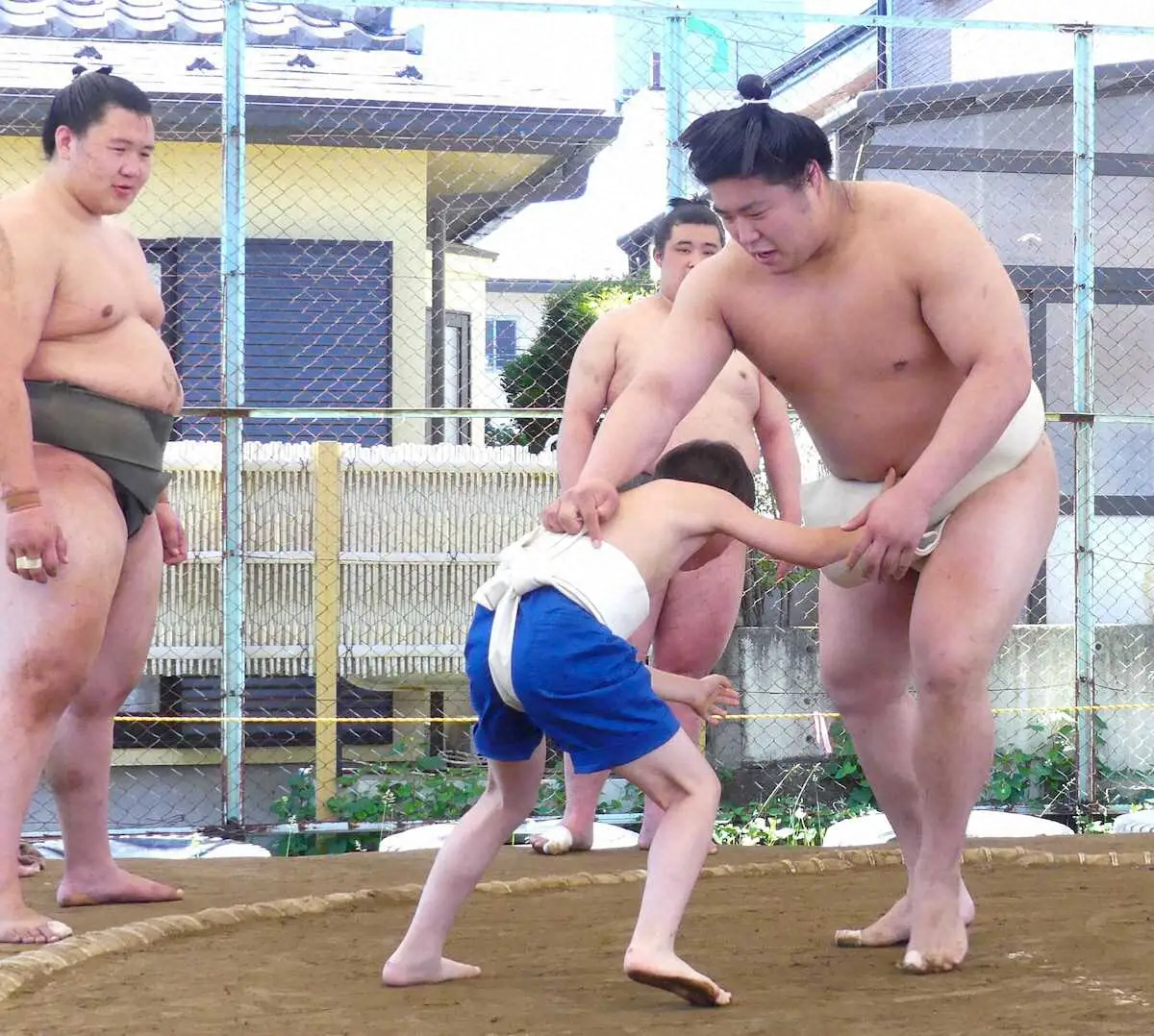 地域の子供と相撲を取る若元春。左は大青山（撮影・前川　晋作）