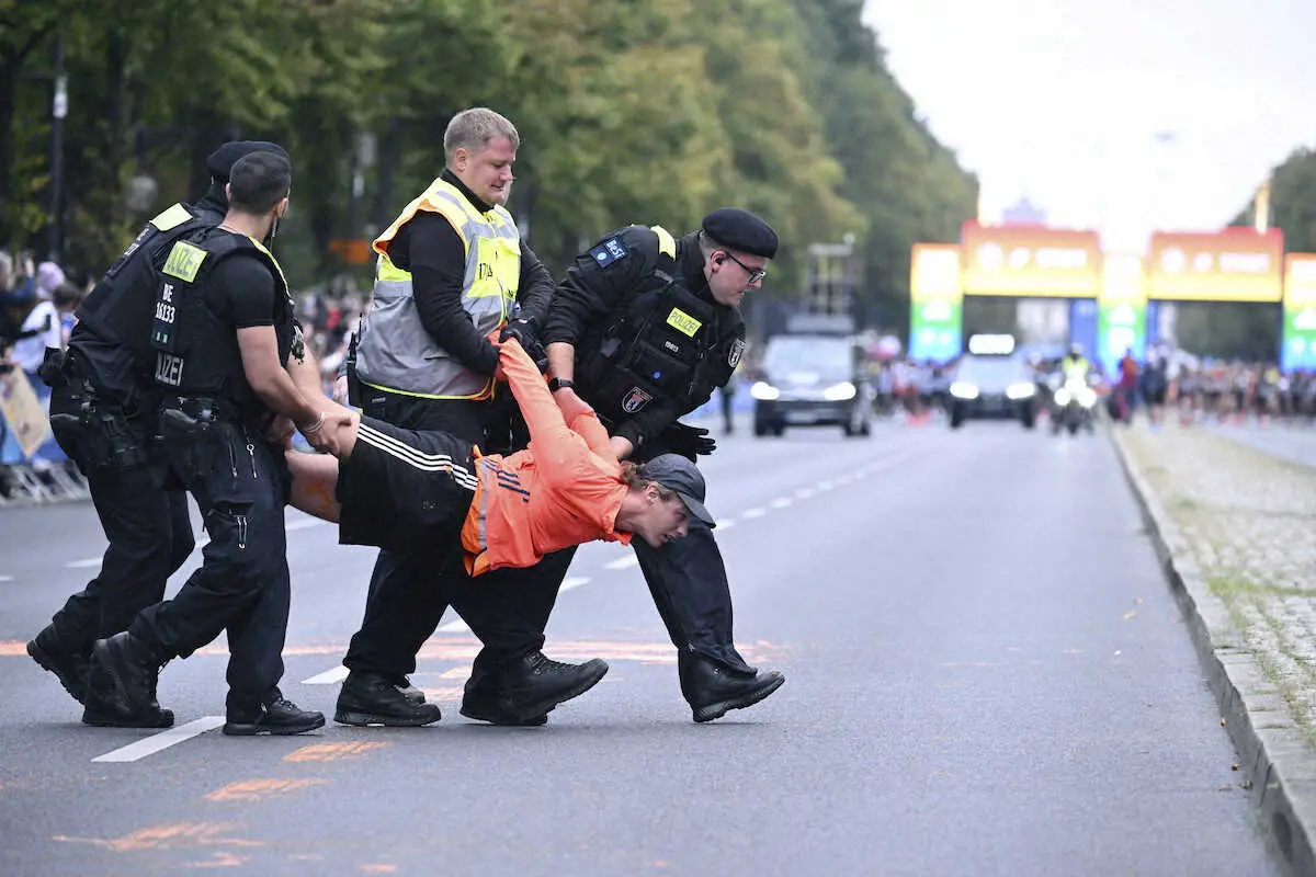 ベルリン・マラソンで警察に排除される環境活動団体のメンバー（AP）