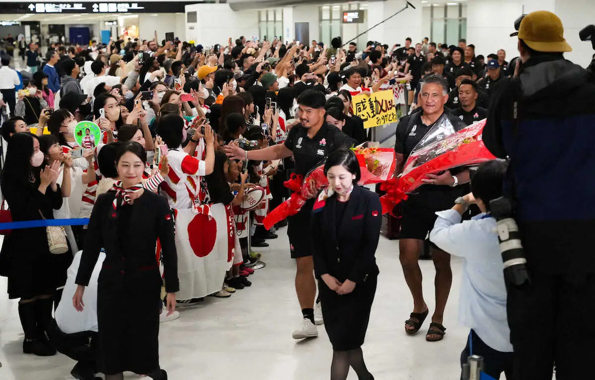 ＜日本代表帰国＞大勢のファンが待ち受ける中、花束を手に帰国する姫野（左）とジョゼフヘッドコーチ（撮影・沢田　明徳）