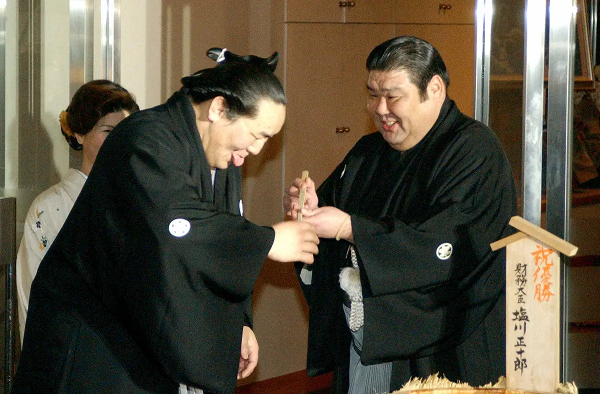 2003年1月、大相撲初場所で優勝し、高砂親方の差し出す祝杯を舌を出して受ける朝青龍