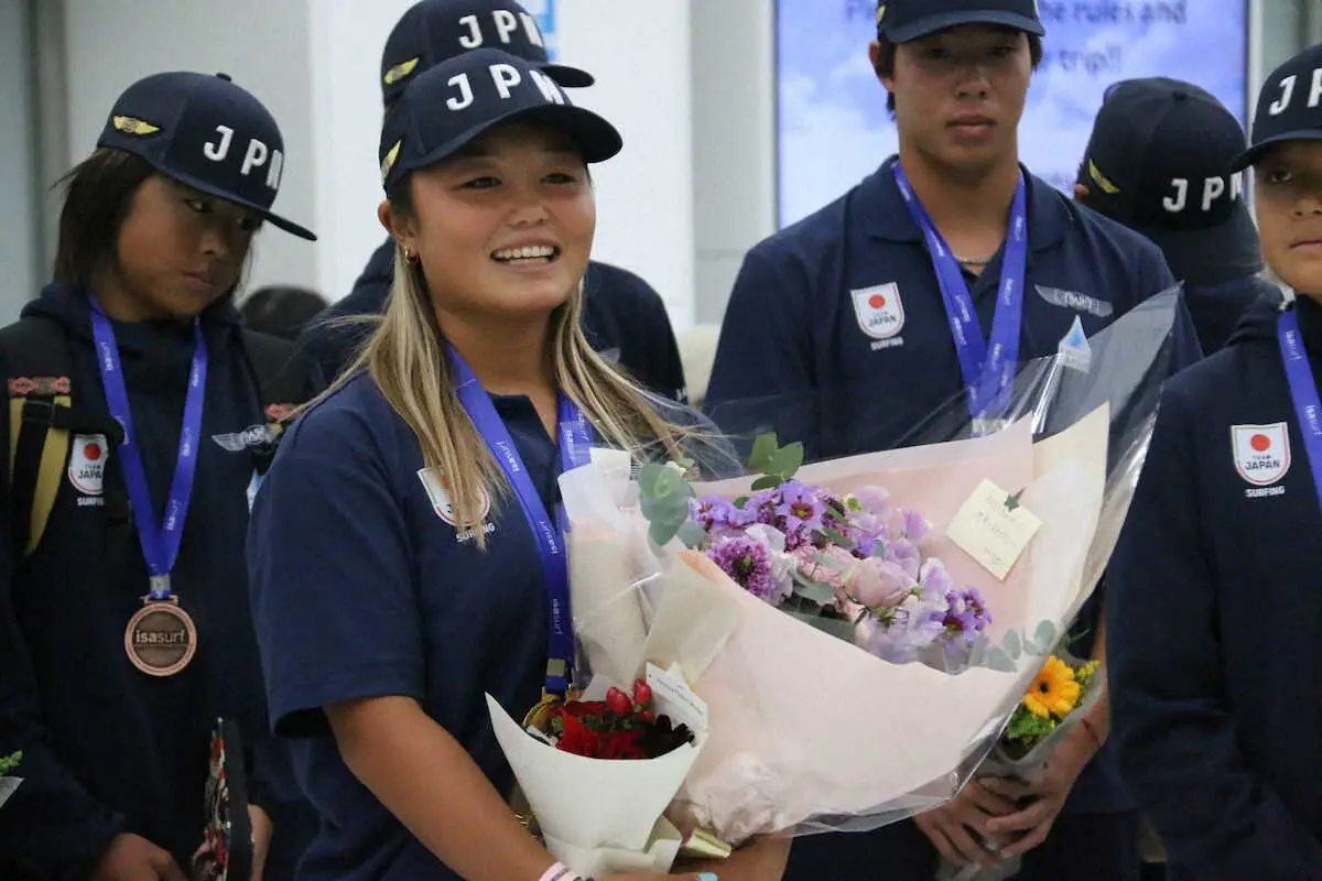サーフィンの世界ジュニア選手権女子18歳以下の部で優勝し、成田空港であいさつする松岡亜音