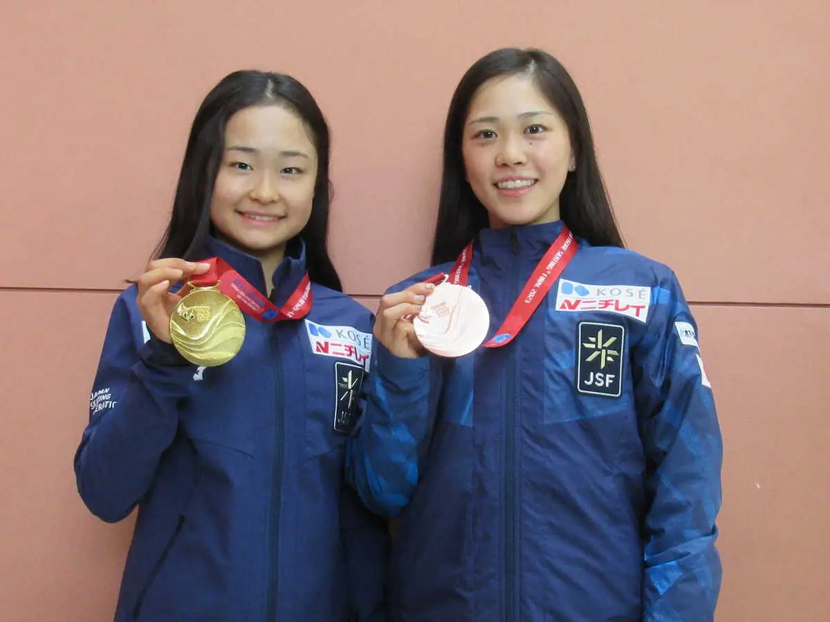 関西空港でメダルを手に笑顔を浮かべる島田（左）と吉田