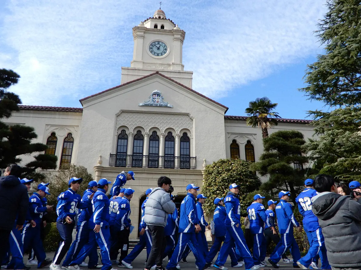 学内パレードで、シンボルの時計台前を歩く関学大ファイターズ