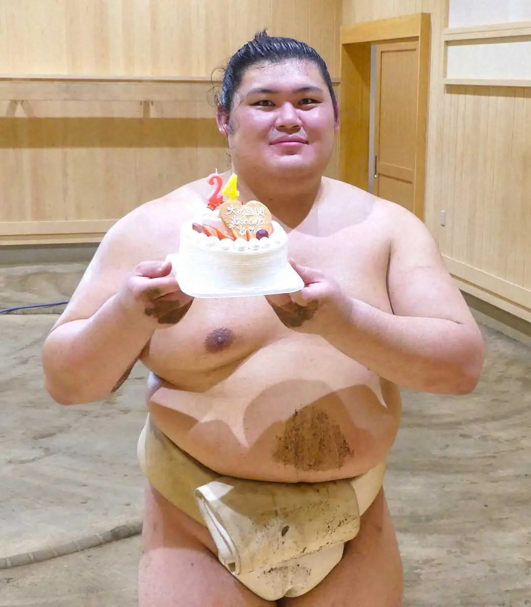 24歳の誕生日を迎え、報道陣から贈られたケーキを手に笑顔の大の里（撮影・前川　晋作）