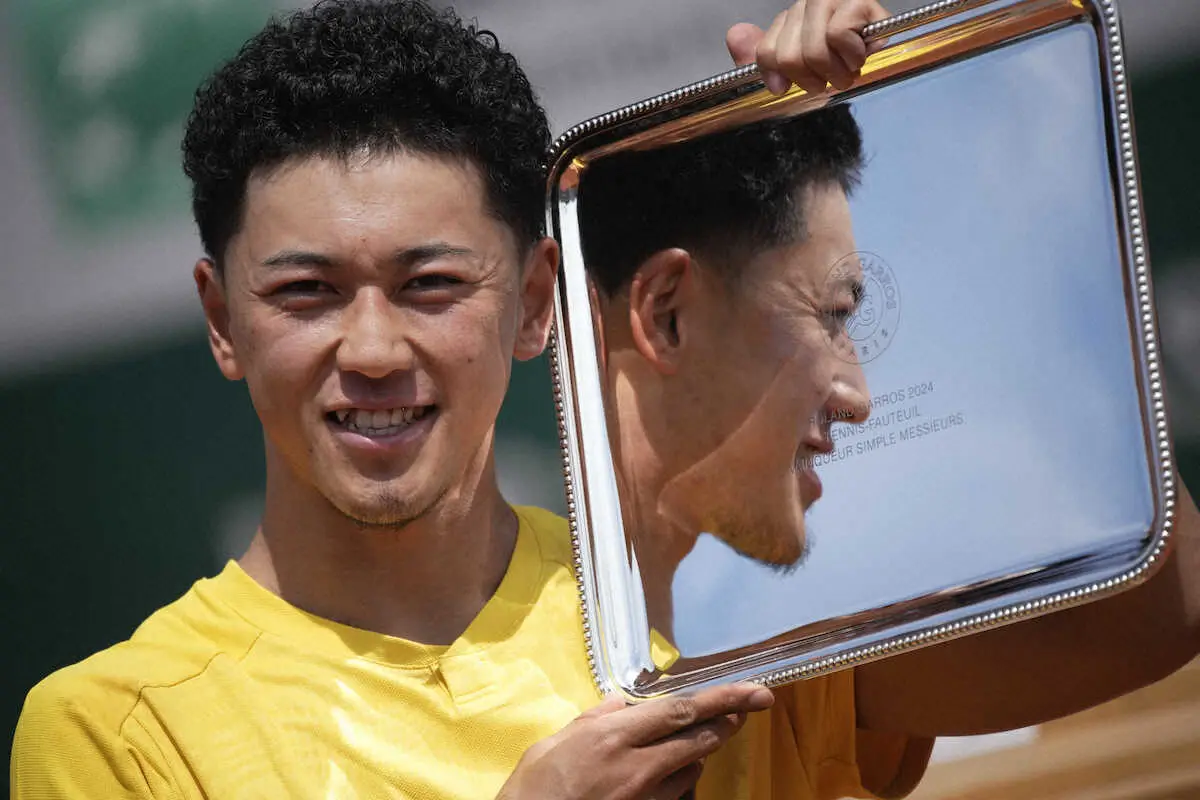 テニスの全仏オープン車いすの部男子シングルスで、2連覇を果たしトロフィーを手に笑顔の小田凱人（AP）