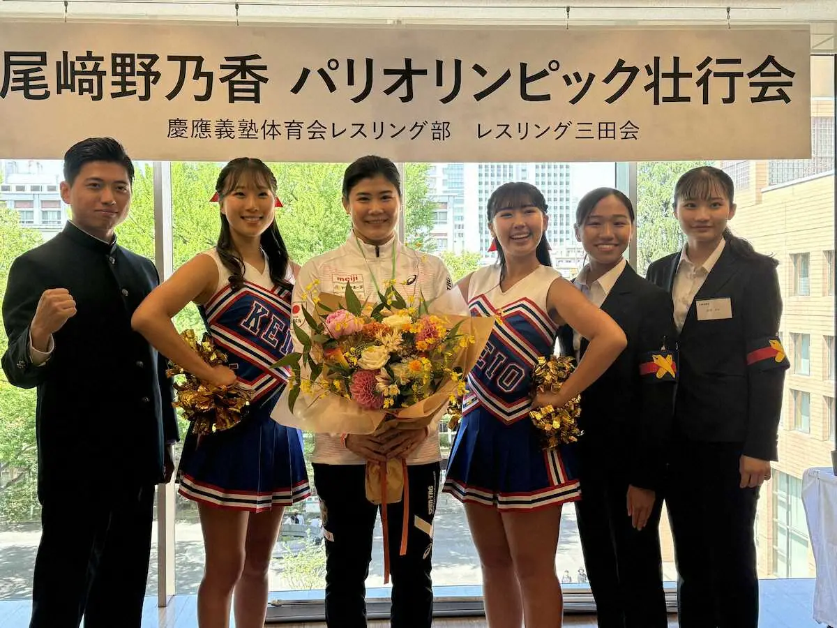 慶大レスリング部の壮行会で応援指導部員と笑顔で記念撮影に応じる尾崎野乃香（左から3人目）