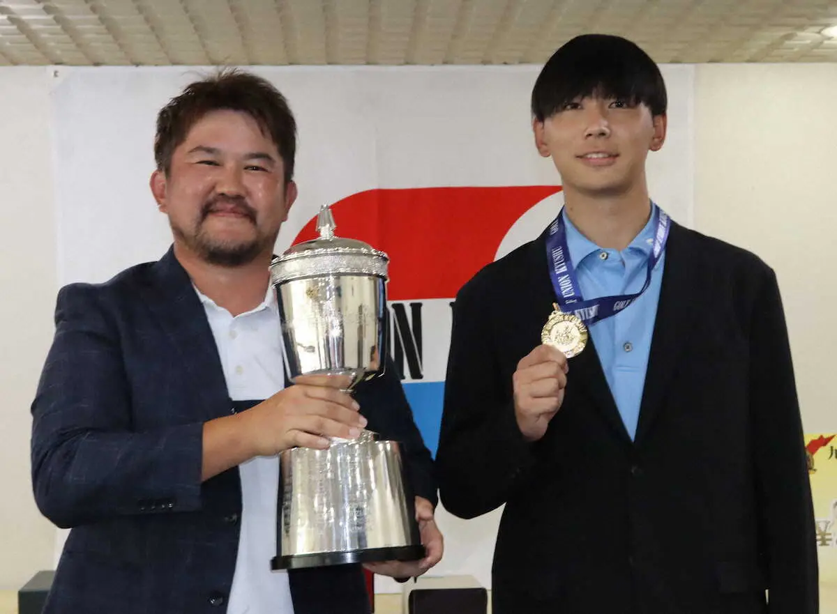 九州オープンゴルフ最終日大会初優勝の林拓希（左）は優勝カップを手に笑顔、右はベストアマの遠藤崇真