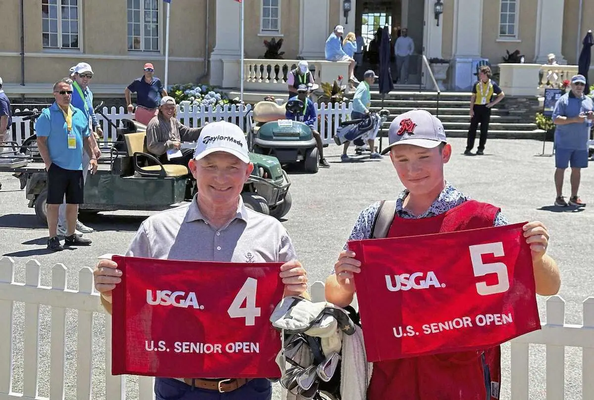 　ゴルフの全米シニアオープン選手権で2ホール連続のホールインワンを達成し、キャディーを務めた息子（右）とともに写真に納まるフランク・ベンセル＝ニューポート（AP＝共同）