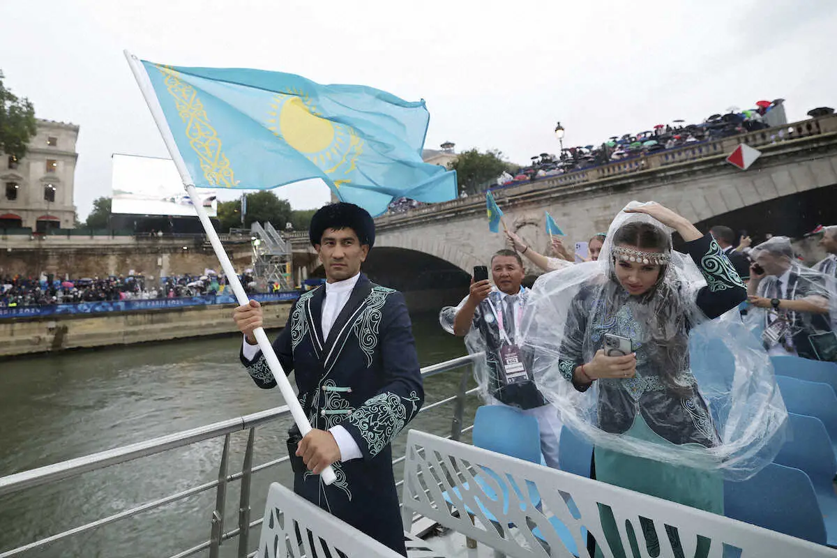 パリ五輪セーヌ川の水上パレードに参加したカザフスタンの旗手を務めるボクシングのアスランベク・シムベルゲノフと陸上のオルガ・サフロノワ（AP）
