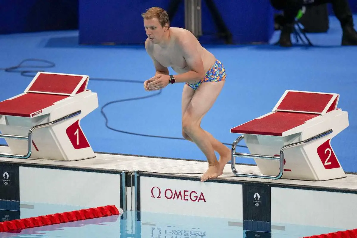 プールの底に“忘れた”米国の水泳選手エマ・ウェバーの水泳帽を回収するために、ライフガードが競技用プールに飛び込む（AP）