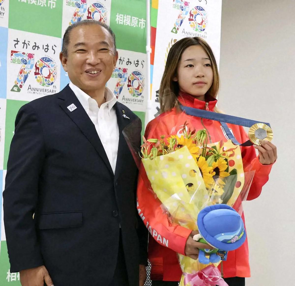 相模原市の本村賢太郎市長（左）と写真に納まるパリ五輪スケートボード女子ストリートで金メダルの吉沢恋