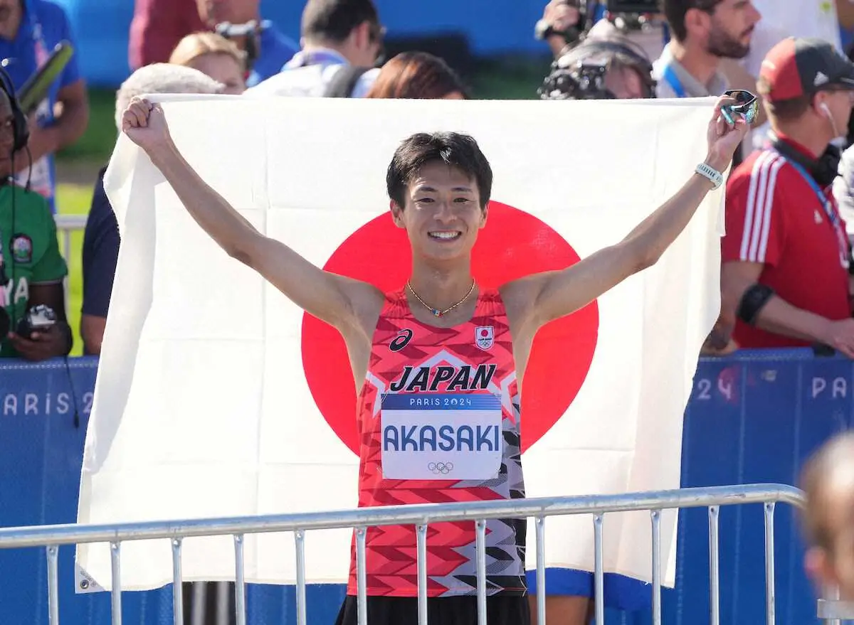 ＜パリ五輪・男子マラソン＞6位でゴールし日の丸を掲げる赤崎（撮影・岡田　丈靖）