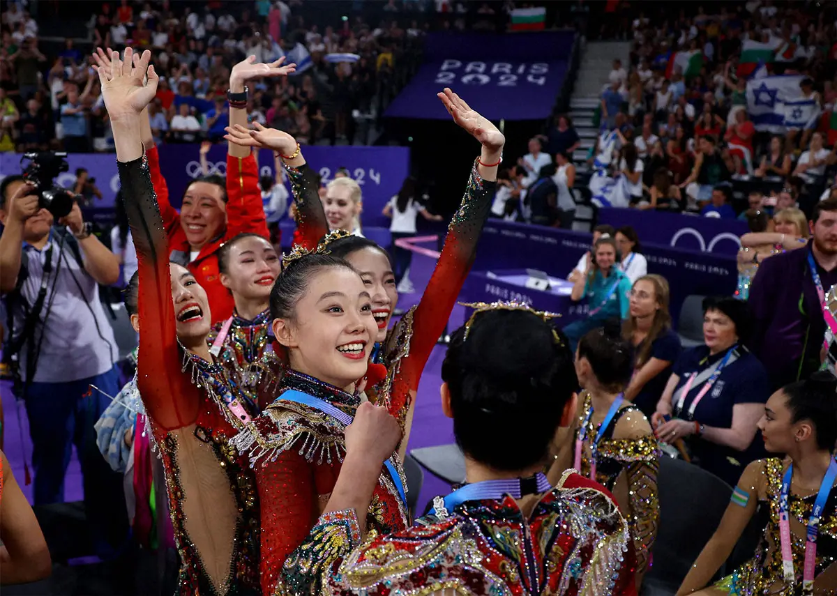 新体操女子団体総合で初の金メダルを獲得した中国のメンバーとスン・コーチブリズニュク・コーチ（ロイター）