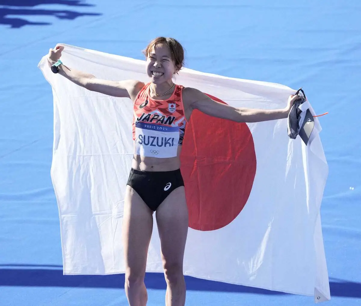 ＜パリ五輪・女子マラソン＞6位に入り笑顔で日の丸を掲げる鈴木（撮影・岡田　丈靖）