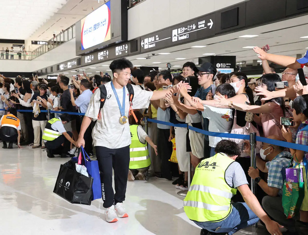 成田空港での出迎えに笑顔でハイタッチの日下（撮影・村上　大輔）